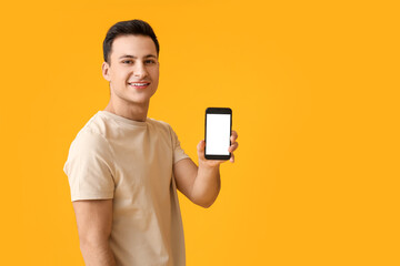 Wall Mural - handsome young man with mobile phone on color background