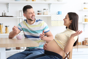 Wall Mural - Beautiful pregnant couple in kitchen