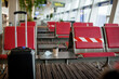 © Sviatlana - A medical mask and a cup of coffee sit on a table in an empty airport, next to the red seats. Coronavirus, social distance, isolation