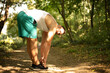 © liderina - Young sports man stretching in the forest.