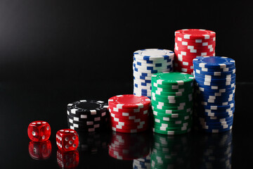 Casino chips and dice on black background