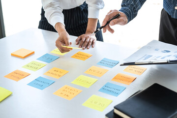 Poster - Two creative business people meeting and planning use note on desk to share idea, Analysis data chart and graph with teamwork strategy brainstorming in office