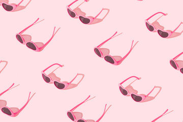 Pink heart-shaped sunglasses with sunny day shadows on bright pink background. Minimal summer love concept.