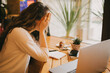 © polinaloves - Young woman student or office worker sitting with her laptop, tired and axhausted.
