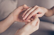 Cropped close-up view of hands girl receiving ring from guy fiance propose moment finger at home indoors