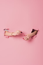 Partial View Of Woman Applying Nail Polish Near Pink Background With Holes