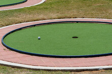 Miniature Or Mini Golf Hole With Ball Near The Hole Hole On Green Artificial Turf Outdoors