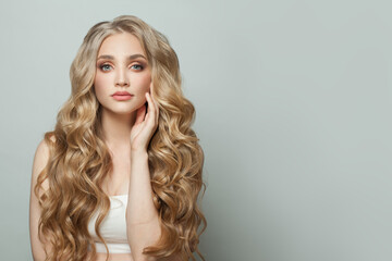 Wall Mural - perfect blonde woman with long healthy blonde curly hairstyle on white background