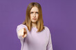 © ViDi Studio - Young serious strict indignant student woman 20s in purple knitted sweater point index finger camera on you command do it isolated on violet color background studio portrait People lifestyle concept