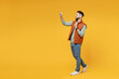 Full length young smiling friendly man in orange vest mint sweatshirt glasses do selfie shot on mobile phone show victory v-sign gesture isolated on yellow background studio. People lifestyle concept.