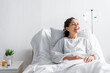 happy african american woman laughing while sitting in hospital bed