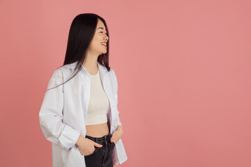 Wall Mural - Asian young woman's portrait on pink studio background. Concept of human emotions, facial expression, youth, sales, ad.