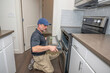 © spatesphoto - Appliance technician installing a oven door