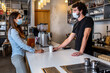 © AH! Studio - Bar owner working only with take away orders during corona virus outbreak - Young man worker wearing face surgical mask giving takeout coffee to customers - Healthcare and Food drink concept