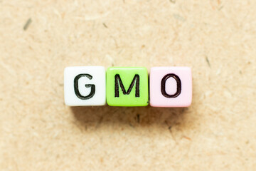 Wall Mural - Color alphabet letter block in word GMO (abbreviation of Genetically Modified Organisms) on wood background