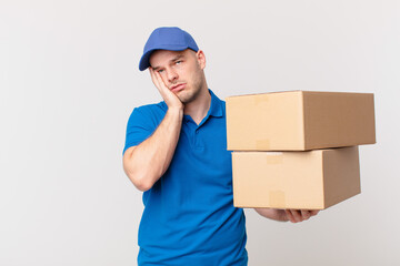 package deliver man feeling bored, frustrated and sleepy after a tiresome, dull and tedious task, holding face with hand