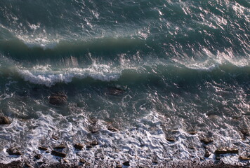 Top view of the sea surf, which rolls over the rocky coast in two waves