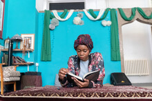 Black Muslim Woman Studying In Blue Room