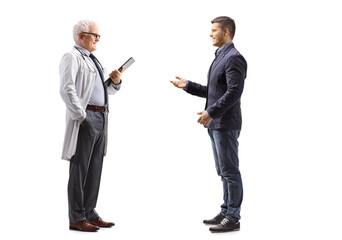 Poster - Full length profile shot of a young man talking to a mature doctor