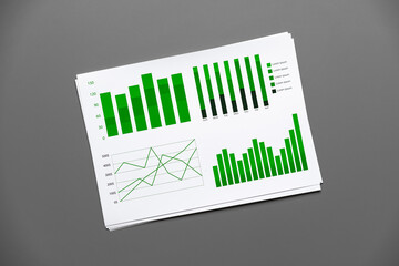 Financial paper with charts and diagrams on gray table