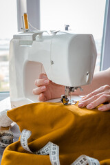 Sewing. Recycling Made by hand from home. The sewing machine and the project  quarantine, lockdown. Hobby, meditation, zero waste, recycling. Girl sews clothes at home on a sewing machine, ecology