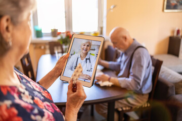 Wall Mural - Senior couple consulting with a doctor on digital tablet
