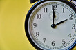 Shot of vintage retro analog clock on yellow background showing 2 o clock