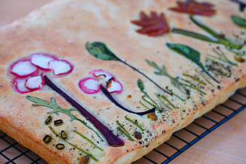 Wall Mural - View of a focaccia bread decorated with a garden made of vegetables on top