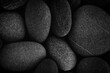 Dark black abstract smooth round pebbles sea texture background