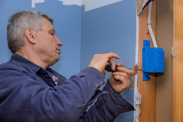 Electrician fasten the electrical box to the beams to place