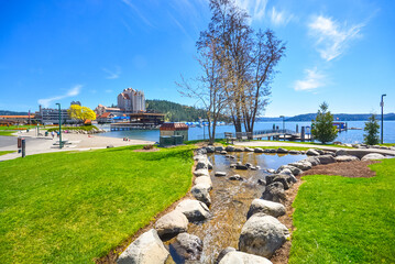 A small stream flows into the lake with the downtown and Tubbs Hill in view in Coeur d'Alene, Idaho, USA