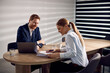 © Drazen - Happy entrepreneurs going through business reports while working together in the office.