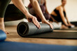 © Drazen - Close-up of  female athlete preparing exercise mat for sports training.