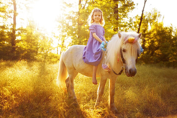 Girl in purple dress hugging white unicorn horse. Dreams come tr