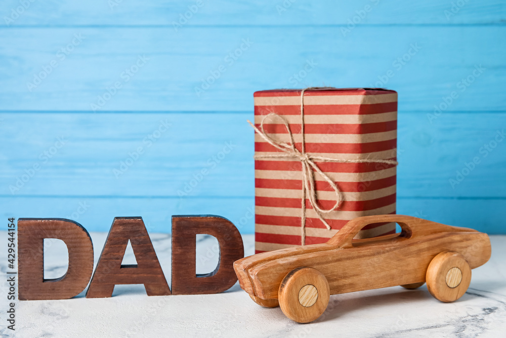 Kid toy with gift for father on table