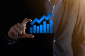 Businessman man holding a graph with positive profits growth. plan graph growth and increase of chart positive indicators in his business.more profitable and growing.