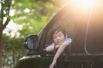 Wall Mural - child holding binoculars out of the car window on summer day