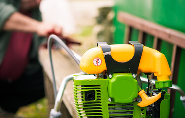 Wall Mural - farmer prepares grass mower for work on farmland soil in spring