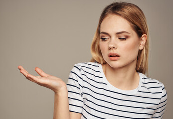 Wall Mural - indignant blonde on beige background in striped t-shirt model cropped view