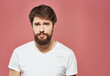 © SHOTPRIME STUDIO - A man in a white T-shirt with a beard on a pink background Copy Space