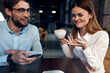 © SHOTPRIME STUDIO - woman drinking coffee at the table next to a man work colleague technology