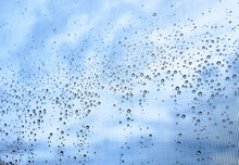 Water Droplets On A Window With A Blue And Cloudy Sky