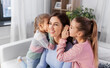 © Syda Productions - people, family and concept - happy mother and two daughters gossiping at home