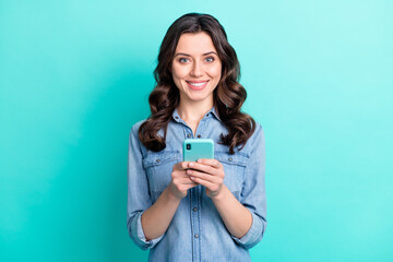 Wall Mural - photo of sweet adorable young lady dressed denim shirt typing modern device isolated teal color back