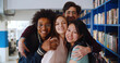 © TommyStockProject - Portrait of happy multiethnic young people posing at camera in school library
