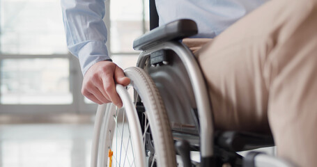 close up of disabled man riding in wheelchair