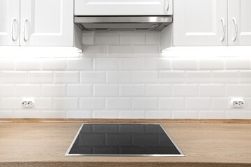 White kitchen with wooden countertop with induction cooktop