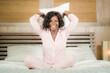© TheVisualsYouNeed - morning portrait of young beautiful and happy afro American woman in pajamas relaxed and cheerful on bed awake in the morning in positive mood smiling