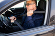 © F8  \ Suport Ukraine - Feeling safe in new car. Confident mature man fastening seat belt while sitting in his car