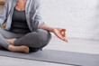 © LIGHTFIELD STUDIOS - partial of mature woman sitting in lotus pose on yoga mat